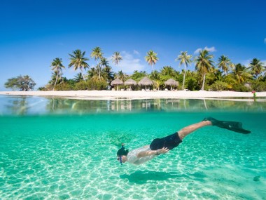 Plaja Matira din Bora Bora, Polinezia Franceză, are ape turcoaz strălucitoare, plaje cu nisip alb şi căsuţe deasupra apei de unde puteţi admira peisajul mirific.
